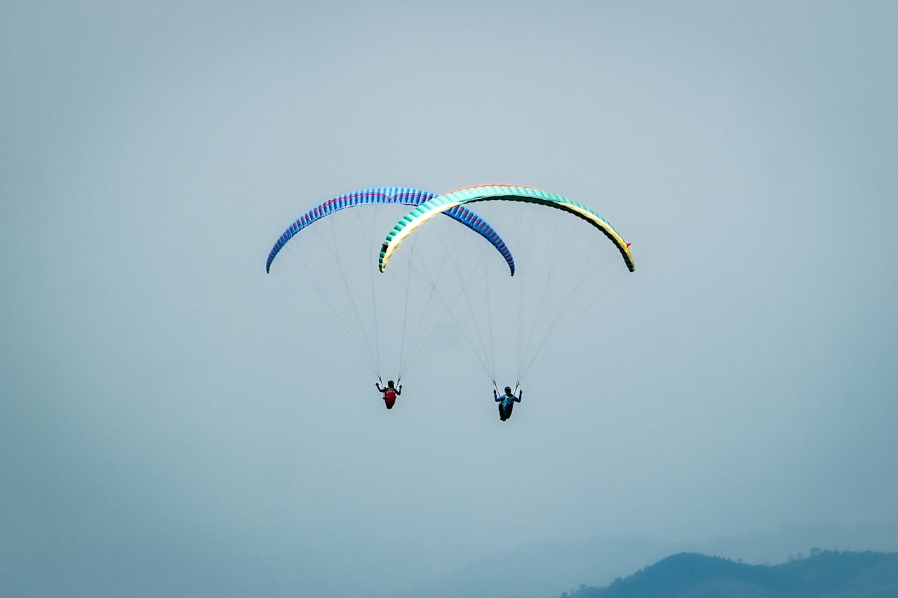 Services Two paragliders soar through the misty skies over Sumedang, West Java, Indonesia.
